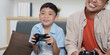 © itchaznong - Family Life: Father and son playing video games together at home