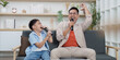 © itchaznong - Family Life: Father and son singing together with microphones at home