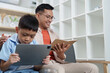 © itchaznong - Family Life: Father and son enjoying digital reading together