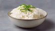© DOUGLAS - Soft fluffy Thai jasmine rice served in simple ceramic bowl, garnished with fresh green onion and sesame seed, creating comforting and inviting meal presentation