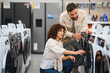 © Serhii - Couple choosing washing machine in electronics store