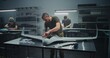 © Framestock - Synchronized Drone Production Team Simultaneously Assembling Large UAV. Technicians in Uniform Simultaneously Assembling UAV Workstations. Concept of Efficiency in Modern Defense Production.