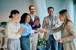 © we.bond.creations - Diverse business team cheering achievement, two women making a deal with a handshake, showing teamwork and partnership