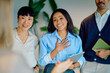 © we.bond.creations - Group of multi-ethnic business people smiling and actively listening to a colleague, showing engagement and positivity during a meeting