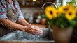 © Pinklife - An elderly person's hands gently wash in a rustic kitchen sink, emphasizing care and tenderness, surrounded by blooming sunflowers, symbolizing wisdom and nurturing spirit of home.