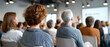 © perfectlab - Audience of diverse adults attentively listening to a speaker during a professional seminar or conference in a modern meeting room
