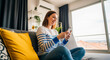 © Pixora - Smiling woman sitting on couch using smart phone in modern apartment home