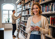 © Alexandr Peers - Community library marketing image with visitor browsing shelves while another person searches for a title, ideal to promote learning programs, research support services and education events