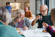 © Halfpoint - Group of seniors having lunch in community center cafeteria.