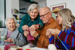 © Halfpoint - Group of senior people learning knitting together with caregiver tutor in a community center.