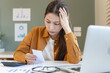 © Pormezz - stressed young asian woman trying to find money to pay credit card debt.
