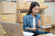 © Pormezz - Young Asian woman owner of small online store packing customer orders in the home office.