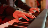 Manos de pianista tocando teclado digital con iluminación cálida y ambiente artístico