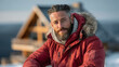 © paffy - Confident mature man in red winter jacket with fur hood smiling outdoors - cozy mountain cabin atmosphere, self-assured masculine energy and winter lifestyle concept