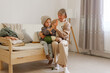 © sementsova321 - A grandmother plays joyfully with her young grandchild on a light-colored sofa at home. They share smiles and laughter in a bright, inviting living space