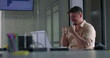 © Marco - Male employee cheering with both fists raised in excitement while working on laptop in office meeting room