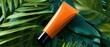 © Studio Nova - The orange cosmetic tube on tropical green leaves with dramatic studio lighting
