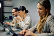 © we.bond.creations - Diverse business people concentrating while working on laptops and drinking coffee during a meeting or collaborative work session