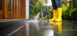 © Studio Nova - The Yellow Boots Powerwashing a Wet Outdoor Patio Floor Near Wooden Door and Greenery