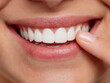 © Sergej Gerasimov - Person smiling with bright white teeth while gently touching their cheek showing healthy gums and confident dental hygiene with natural skin texture