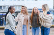 © Iryna - Friends enjoying a sunny day outdoors while laughing and sharing stories in the city