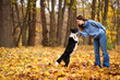 © New Africa - Woman walking her cute dog in autumn park, space for text