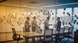 © f_bossa - A blurred view of a modern office meeting room with people collaborating around a conference table, surrounded by colorful sticky notes on glass walls.