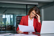 © Stock 4 You - Confused mature trader businesswoman looking disappointed at loan tax paper document using laptop pc computer having stress. Business woman ceo holding hand near temples, feeling stressed in office