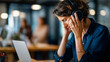 © Kateryna - Tech fatigue in coworking faceless figure with noise canceling headphones removed phone facedown on notebook background defocused people burnout recovery tech fatigue