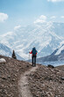 © Soloviova Liudmyla - Lonely Climber woman with backpack and trekking poles during Lenin peak ascent with mountain peaks and glaciers in background. Extreme active people, high-altitude mountaineering concept image