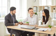 © Studio Romantic - Couple of customers with a financial consultant or investment agent in an office, signing an important contract. Meeting highlights trust and professional guidance in managing financial decisions.