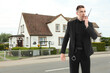 © New Africa - Security guard in uniform using radio near house outdoors. Private property protection