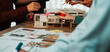 © InfiniteFlow - A group of professionals engages in an architectural design session, using a scale model, sticky notes, and creative tools to enhance collaboration and brainstorming efforts. SACTR