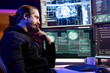 © DC Studio - Pensive cybercriminal coding on PC, brainstorming ways to evade security with stealth malware. Evil man thinking how to use exploit hiding malicious code from detection systems