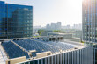 © Yic Ma/Stocksy - modern urban building with solar panels on rooftop