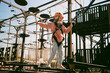 © Sergey Narevskih/Stocksy - Girl balancing on ropes at adventure park
