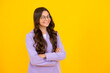 © Olena - Teenage girl kid with crossed arms, looking at camera, isolated on yellow studio background.
