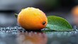 © gor9 - Close-up of a wet orange fruit with a green leaf, covered in water droplets, on a dark reflective surface.