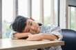 © Yic Ma/Stocksy - Boy resting head on table in quiet indoor space