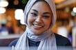© Jovo Jovanovic/Stocksy - Smiling woman in hijab enjoying a warm conversation at a cafe
