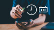 © chaylek - A person using a smartphone with digital icons of a check mark, clock, and calendar, symbolizing task completion, time tracking, scheduling, and productivity management in a modern digital workflow.