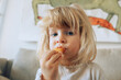© AUDSHULE/Stocksy - Cute toddler eating snack