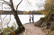 © Diego Martin/Stocksy - Two Women Standing on Lakeside Trail in Scenic Autumn Forest
