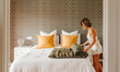 © Marco Govel/Stocksy - Bed styling routine with woman folding blanket