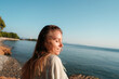© Lucas Ottone/Stocksy - Young woman smiling at the seaside
