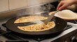 © Irfan - Savory pancake transformation: A culinary master at work, delicately flipping a golden, tantalizing pancake on a sizzling griddle, releasing aromatic steam and promising a delicious experience.