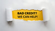 © Sabbir Media - Torn white paper revealing yellow background with black text message asking bad credit we can help isolated on white background