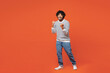 © ViDi Studio - Full body young smiling happy Indian man wear striped sweatshirt casual clothes doing winner gesture celebrate clenching fists say yes isolated on plain red orange background studio Lifestyle concept