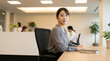 © @ArtUmbre - Serious Young Japanese Businesswoman Sitting at Desk in Modern Office