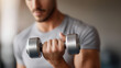 © Denis Yevtekhov - Focused athletic man lifting dumbbell defocused gray sportswear, faceless neutral background, strength visualization detail, blurred training setting, fitness concept, motivation i